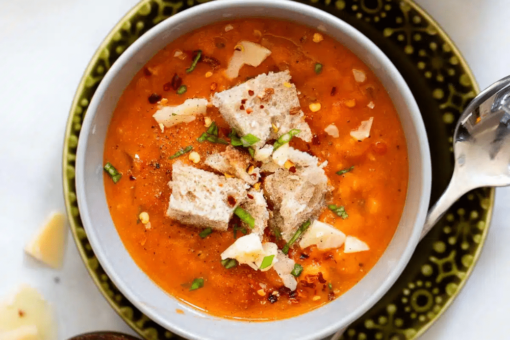Overhead, close up view of Tuscan soup in a bowl with a spoon.