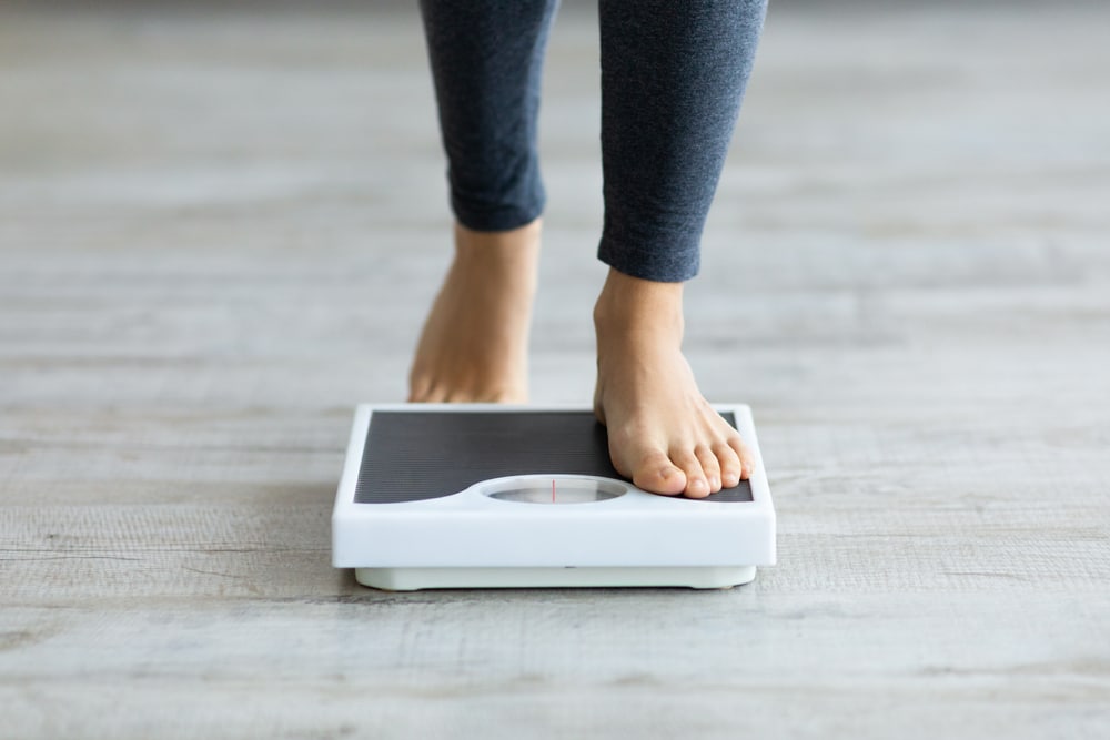 Close up of a foot stepping onto a scale.