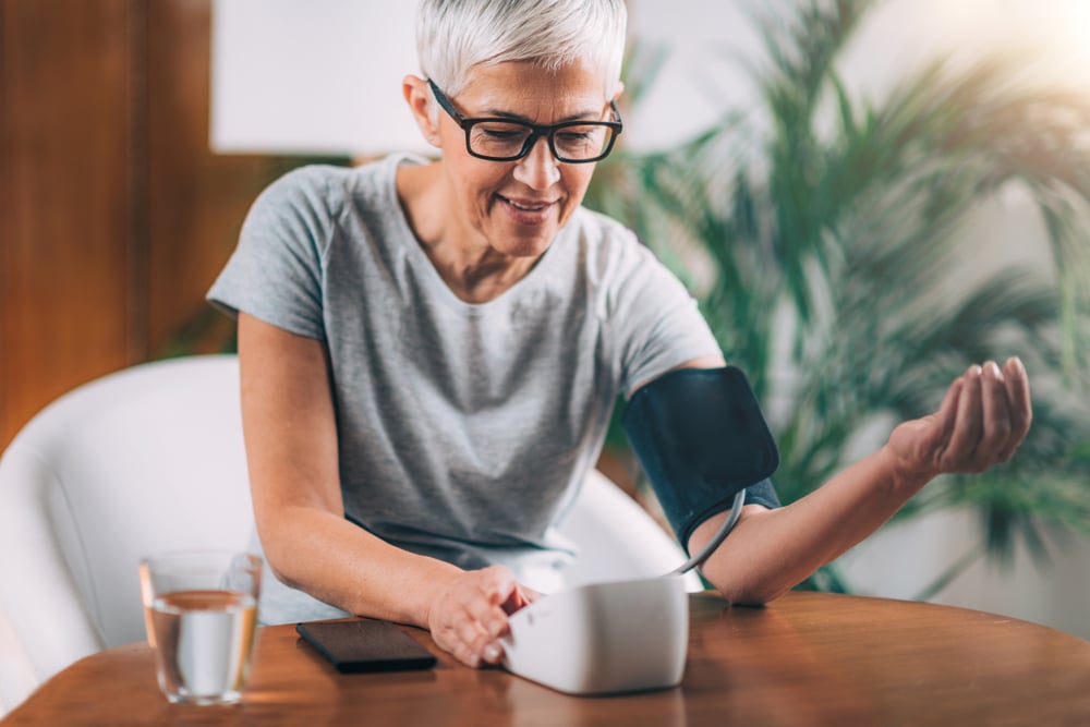 Senior woman checking blood pressure at home.