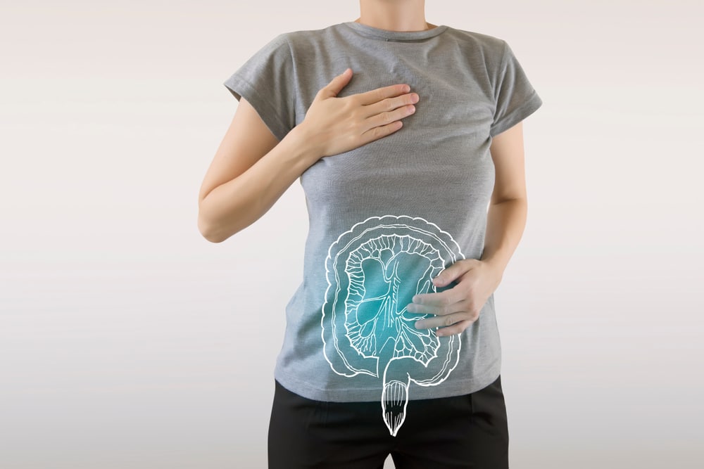 A woman in a grey tshirt with a blue digital image of her intestines over top.
