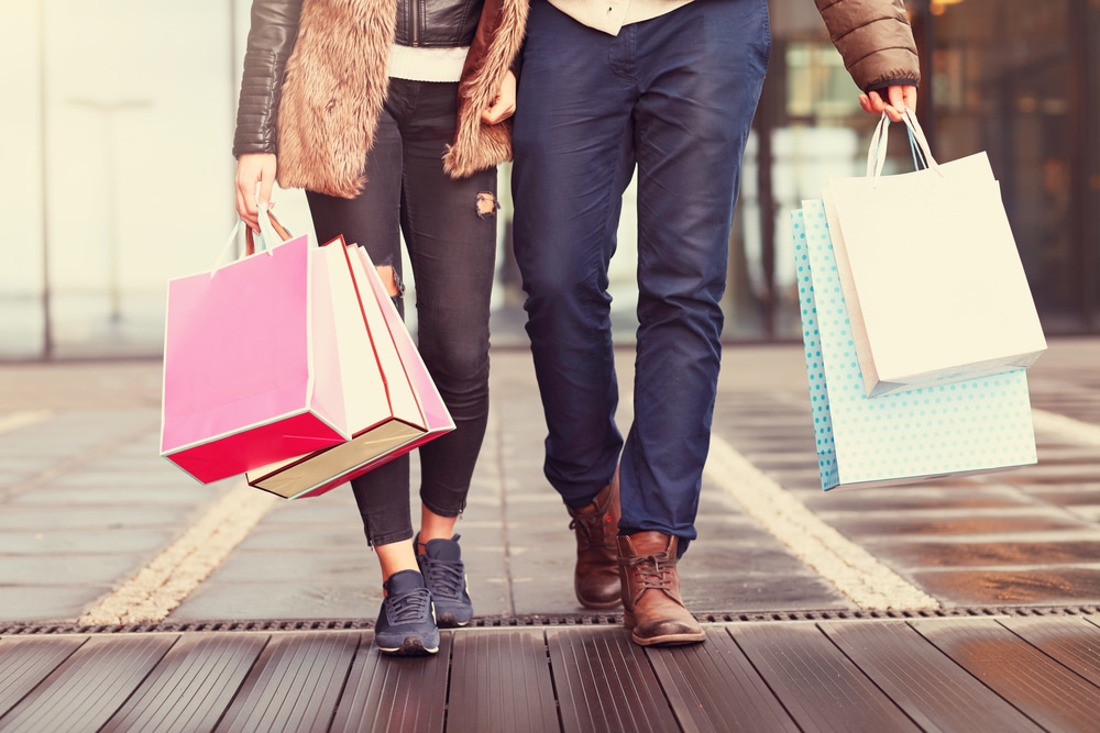 Midsection of a couple walking with shopping bags.
