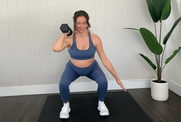 Personal trainer demonstrating offset squat